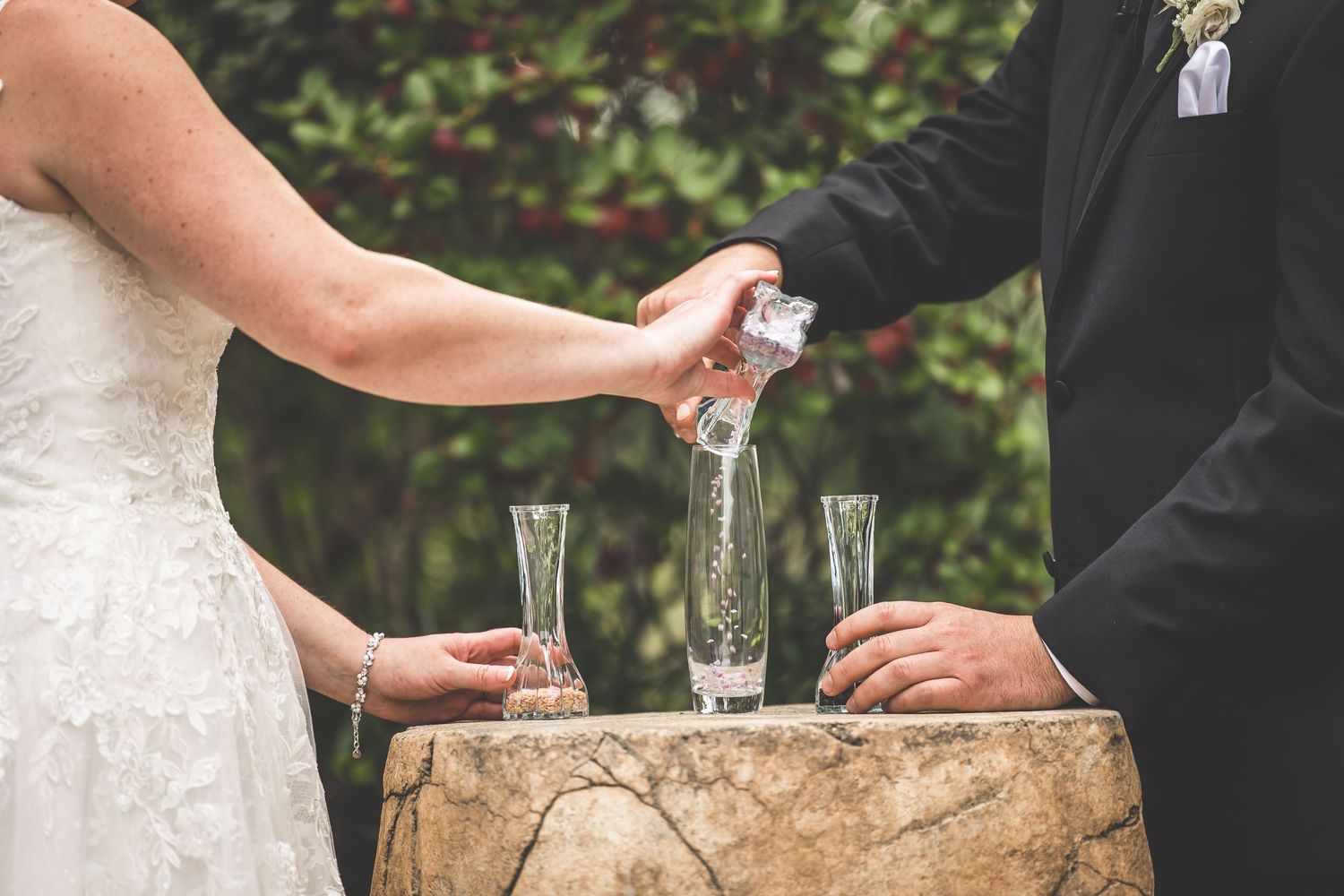 Close-up of champagne toast during outdoor wedding ceremony.