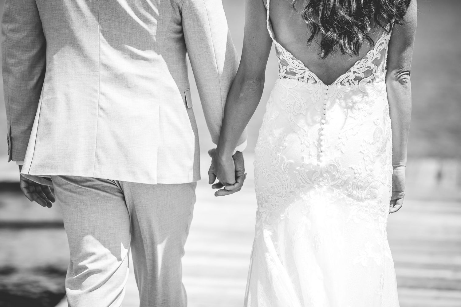 A bride and groom hold hands during their waterfront wedding ceremony.