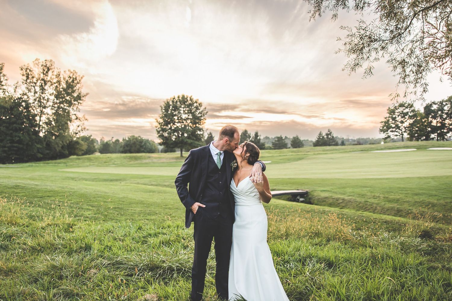 Romantic couple portraits at golden hour on a scenic golf course.