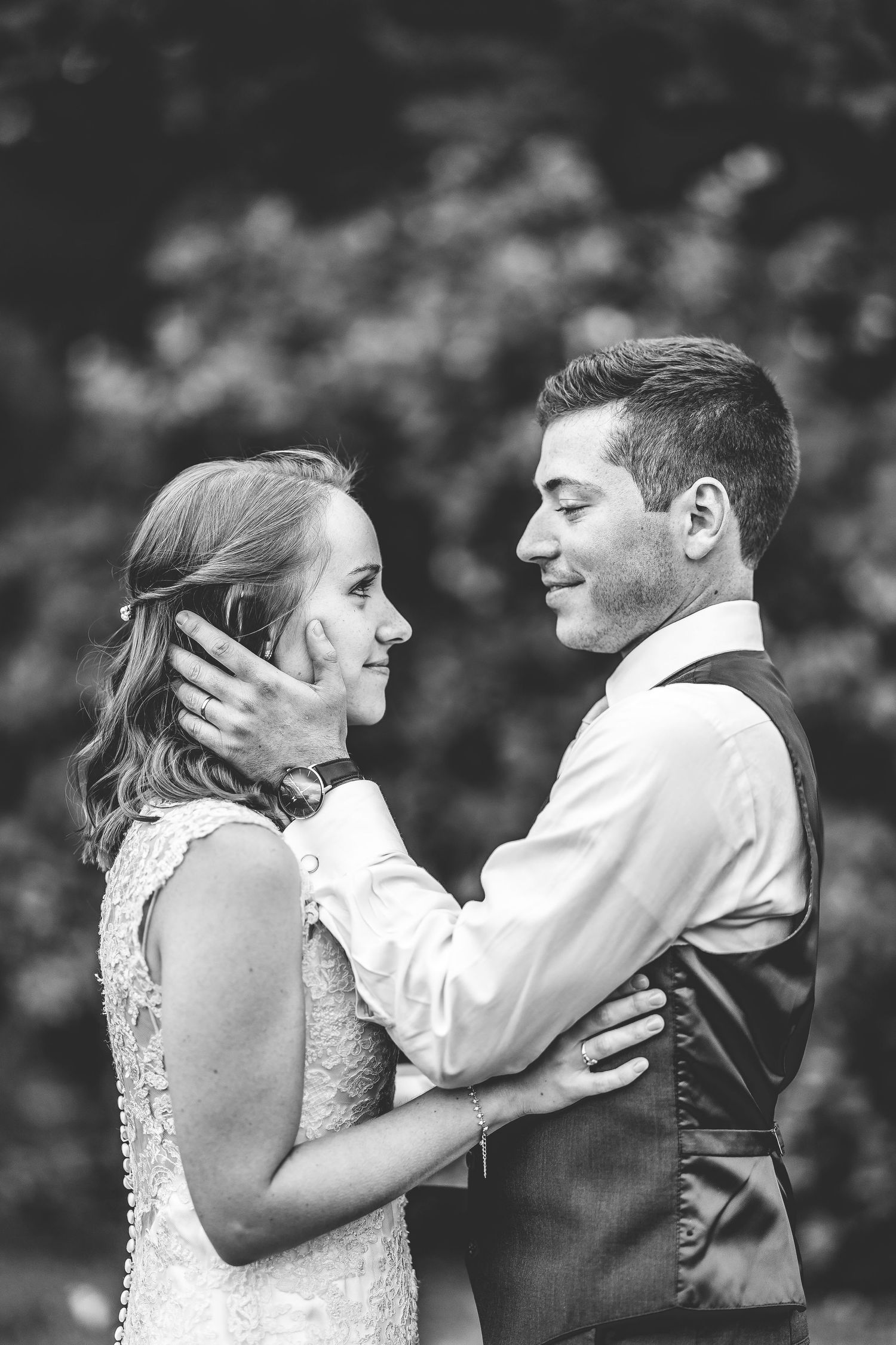 Black and white intimate portrait of newlyweds sharing a tender moment.
