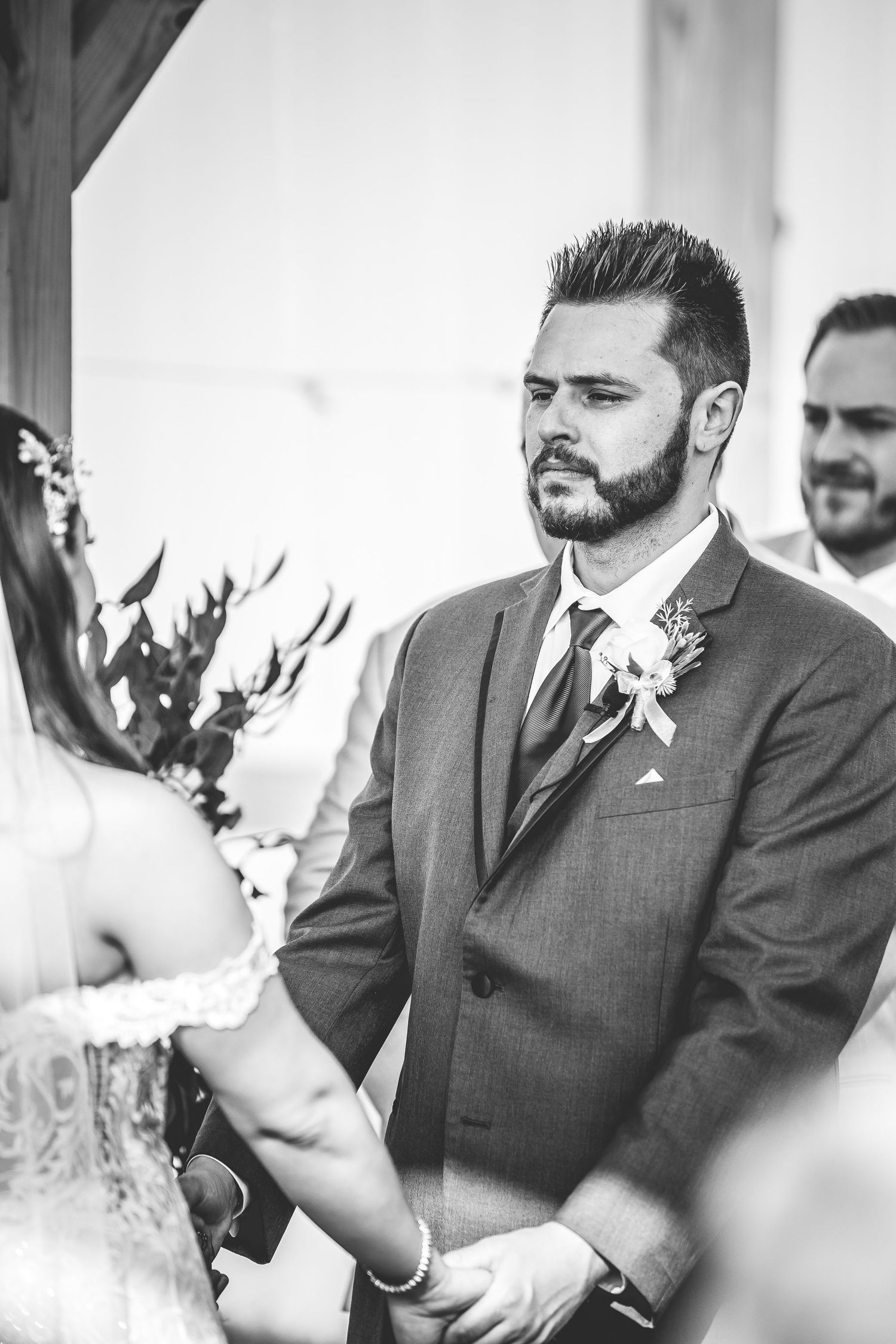 Intimate wedding ceremony moments captured in black and white under a wooden pavilion.