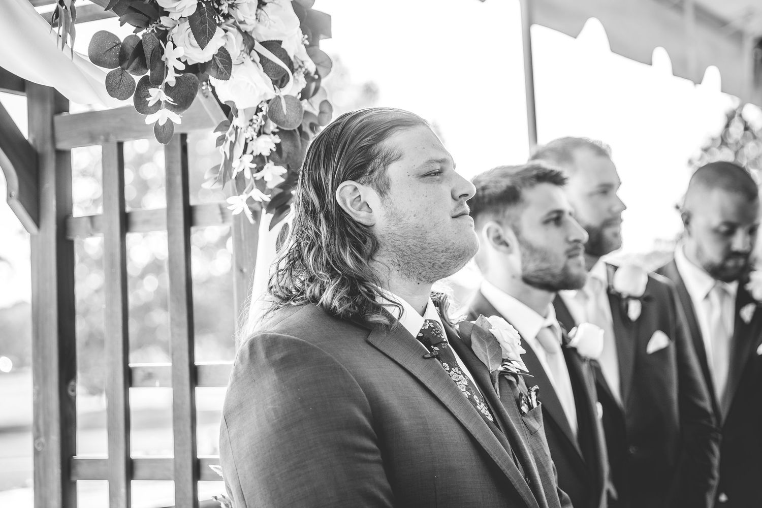 Black and white photo of wedding ceremony guests watching emotional moment.