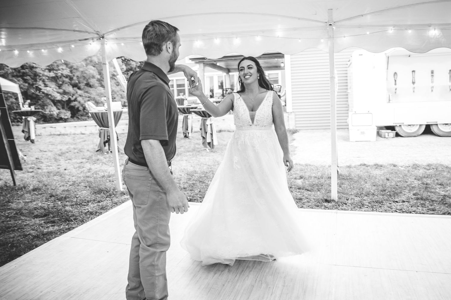 Black and white photos capture candid moments during indoor wedding reception under tent lighting.