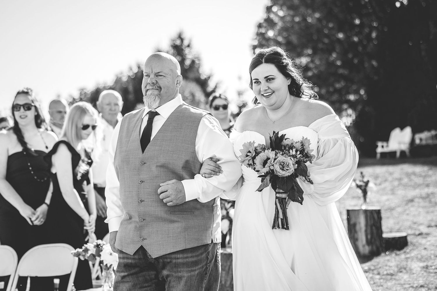 Black and white photo of wedding ceremony guests celebrating outdoors.