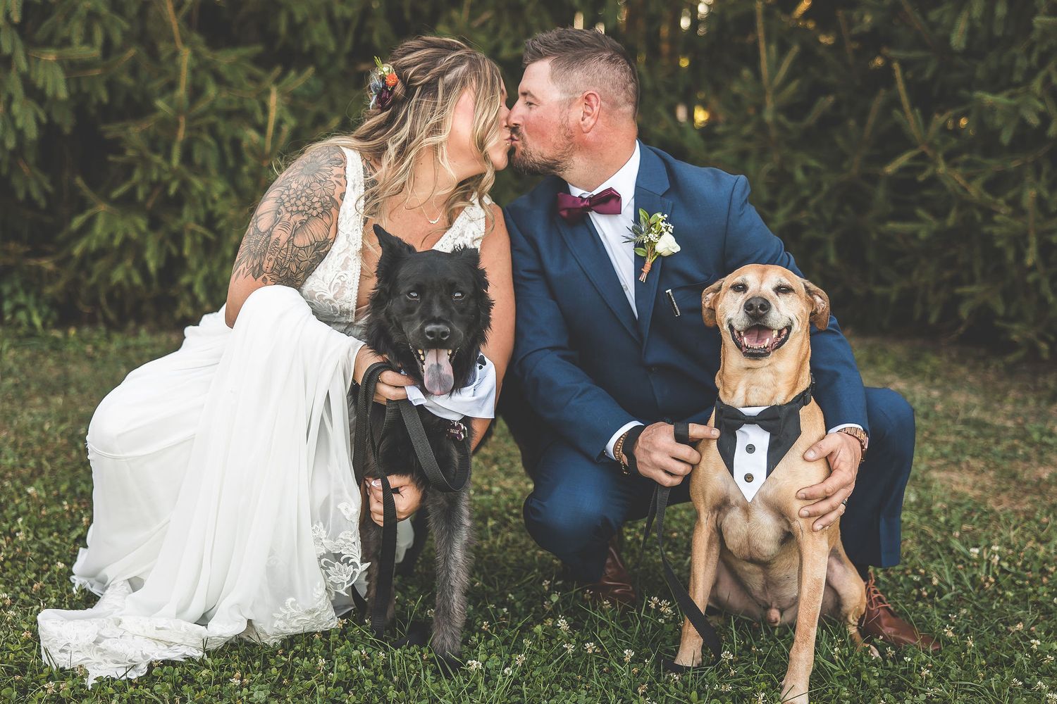 Newlyweds share intimate moment with their pet dog during outdoor photo session.