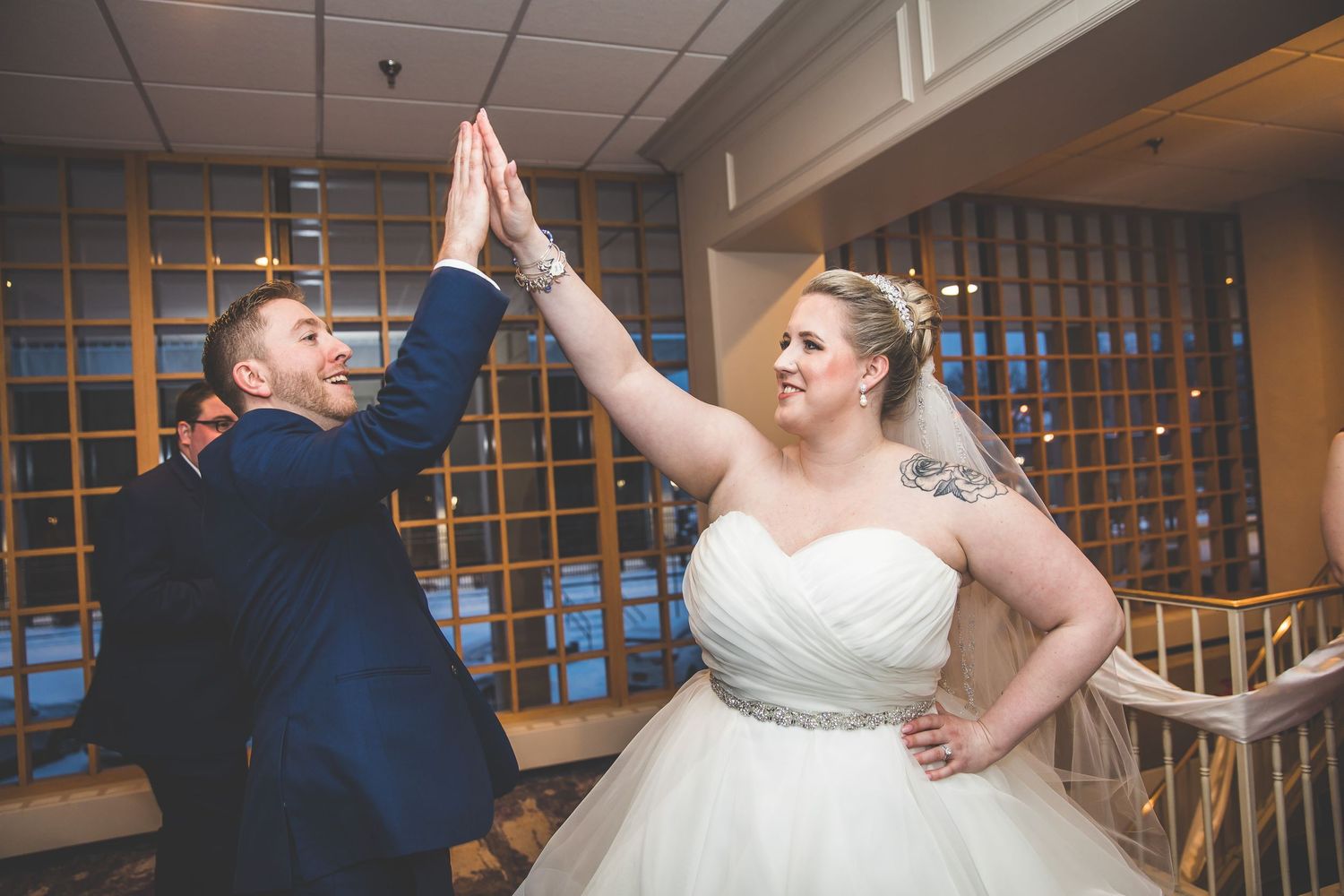 Newlyweds share their first dance under elegant ballroom lighting while guests watch.