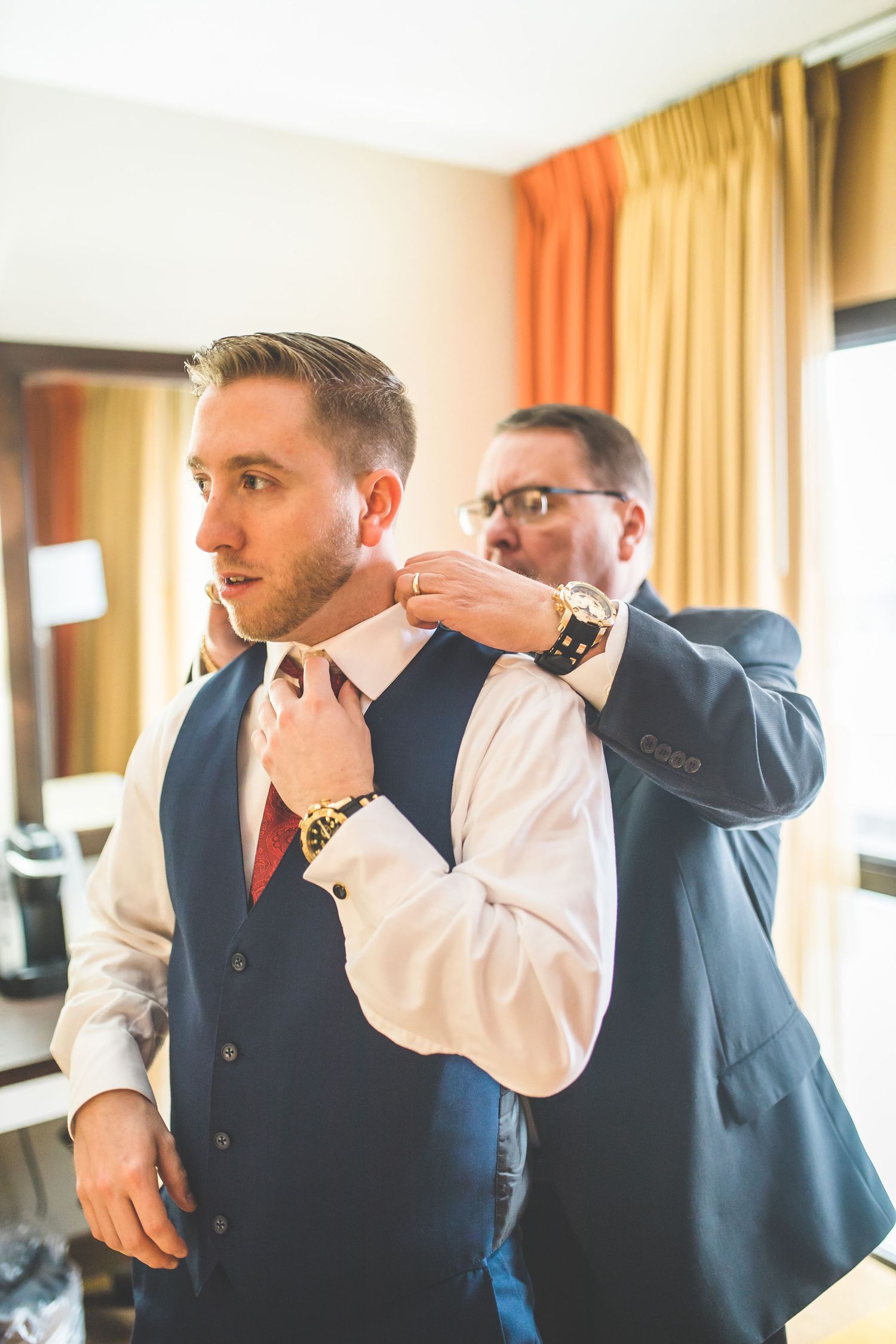 Two people in formal attire preparing for special occasion.