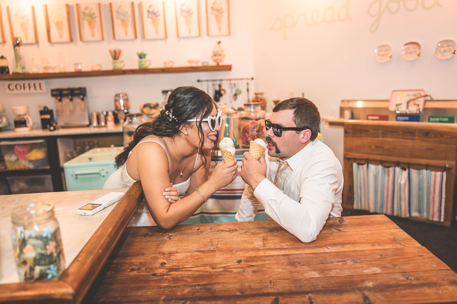 Casual engagement photos taken in a cozy coffee shop setting with rustic decor.