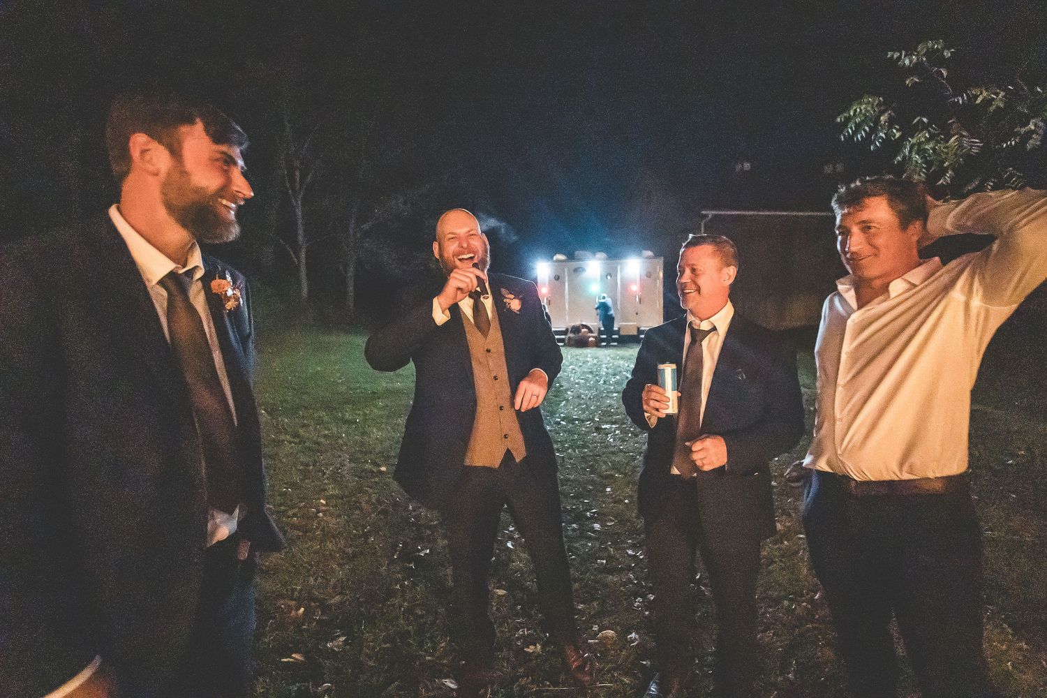 Wedding guests mingling outdoors during an evening celebration.
