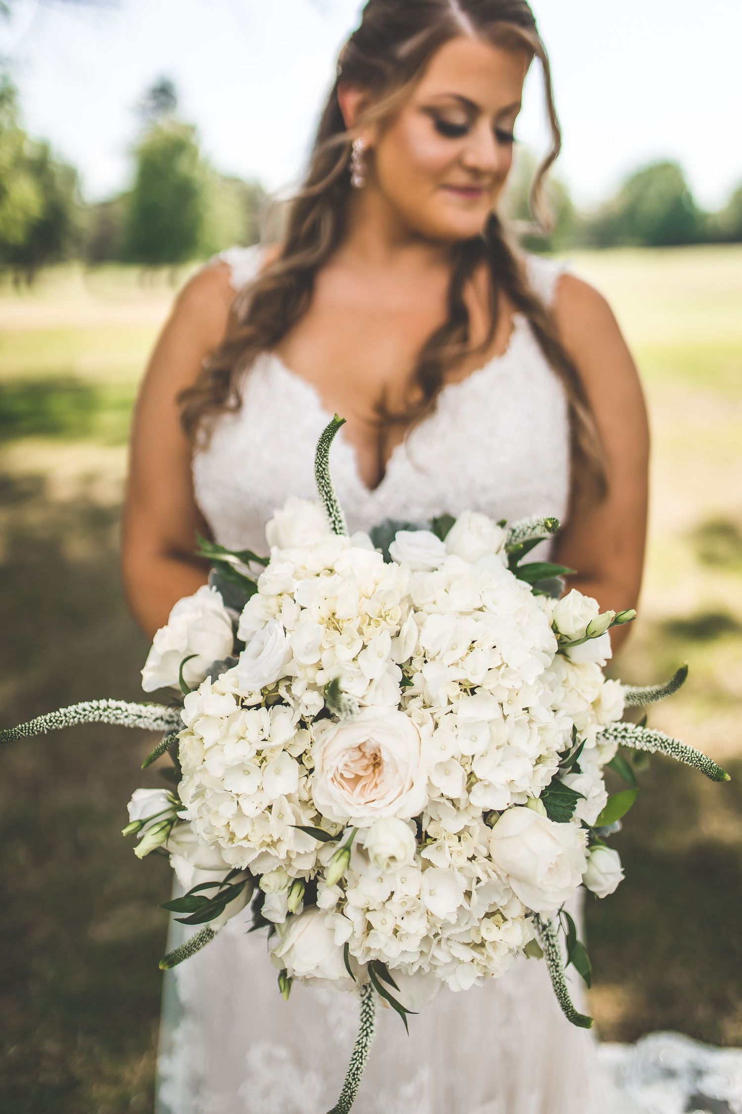 Stunning white wedding bouquet featuring hydrangeas, roses and delicate greenery.