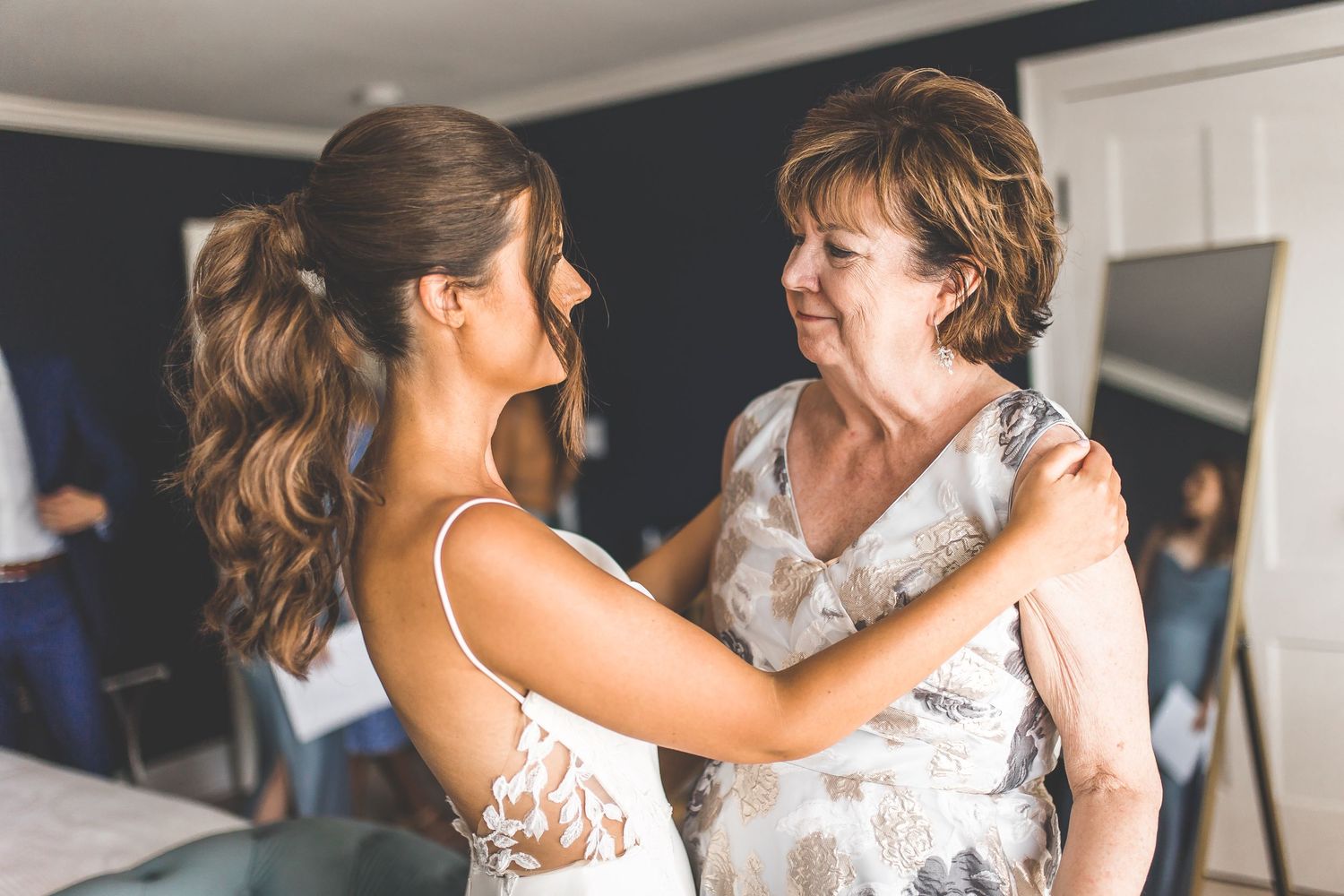 Wedding party members share emotional embraces while getting ready for the ceremony.