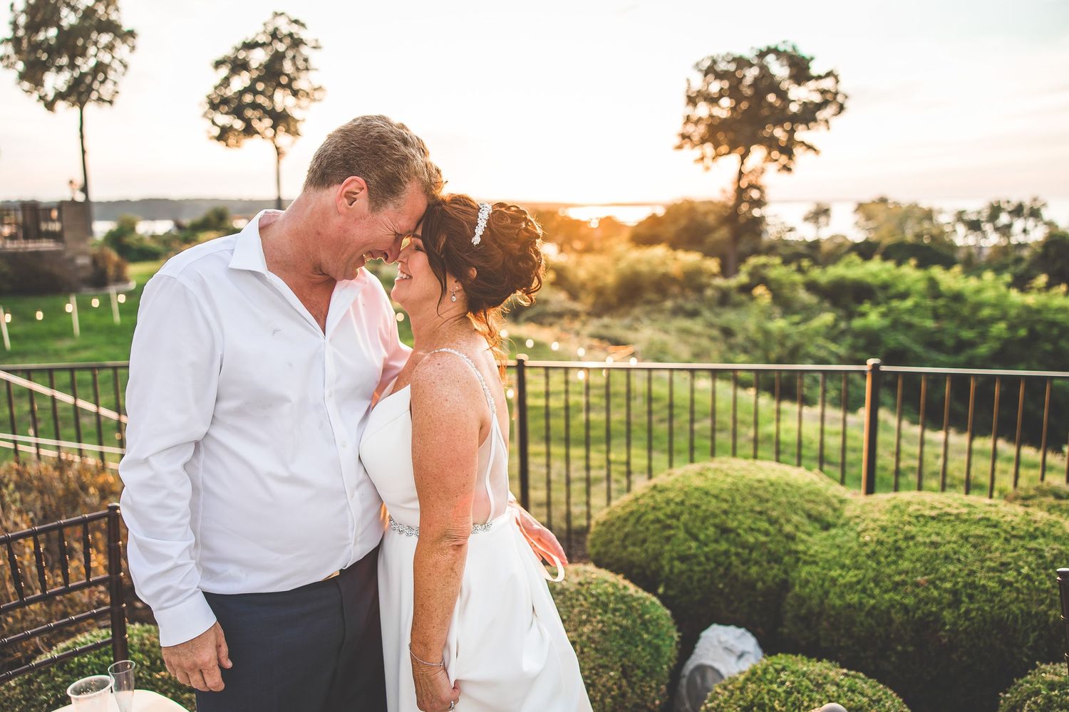 Intimate wedding portraits captured during sunset with natural landscape backdrop.