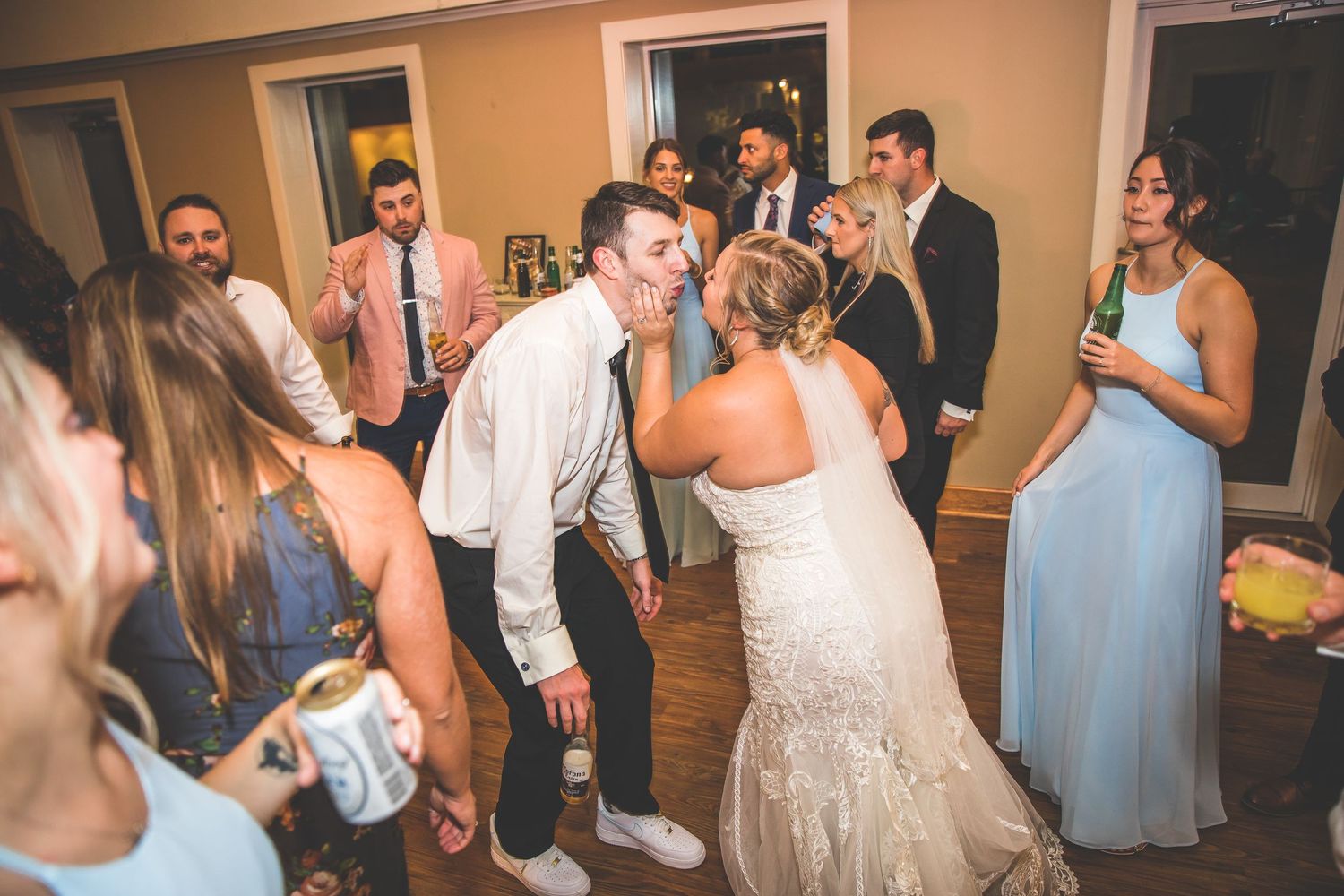 Wedding party dancing and celebrating in a reception hall.