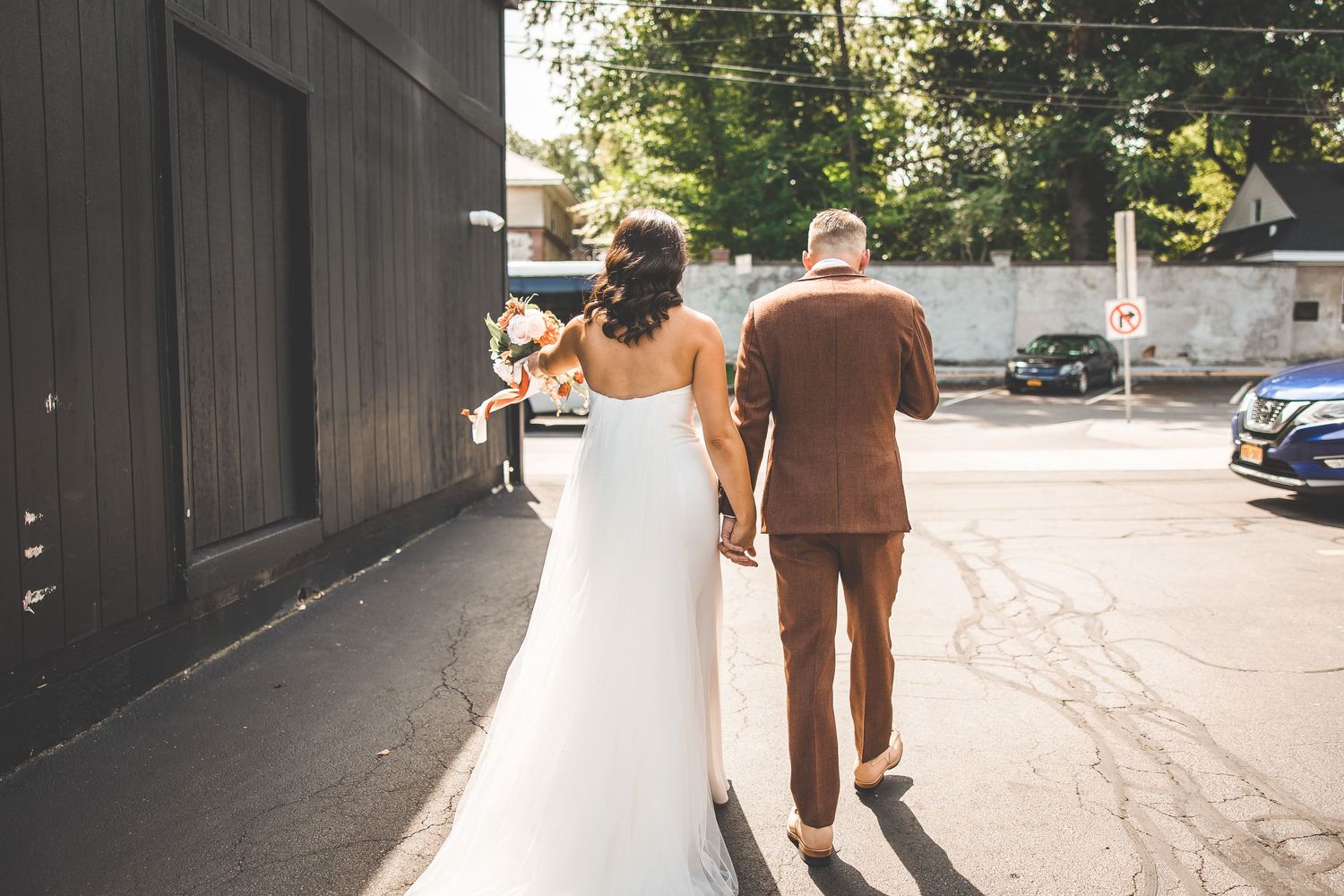 Sunlit outdoor wedding photos captured in an urban alley with dramatic shadows.