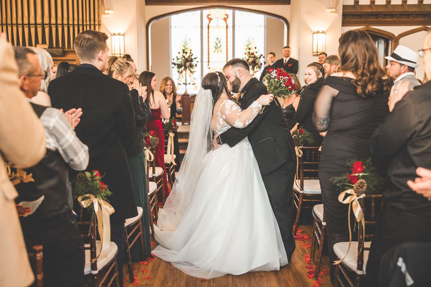 Wedding guests celebrating in a traditional church setting with wooden paneling.