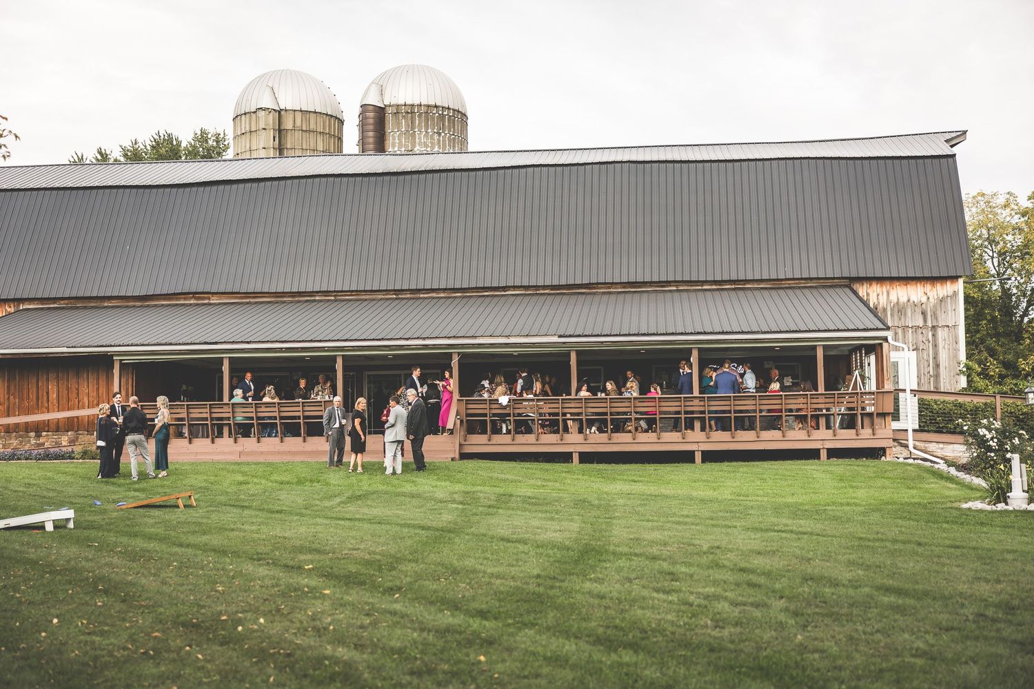 Long industrial farm building with metal roof and silos visible in background.