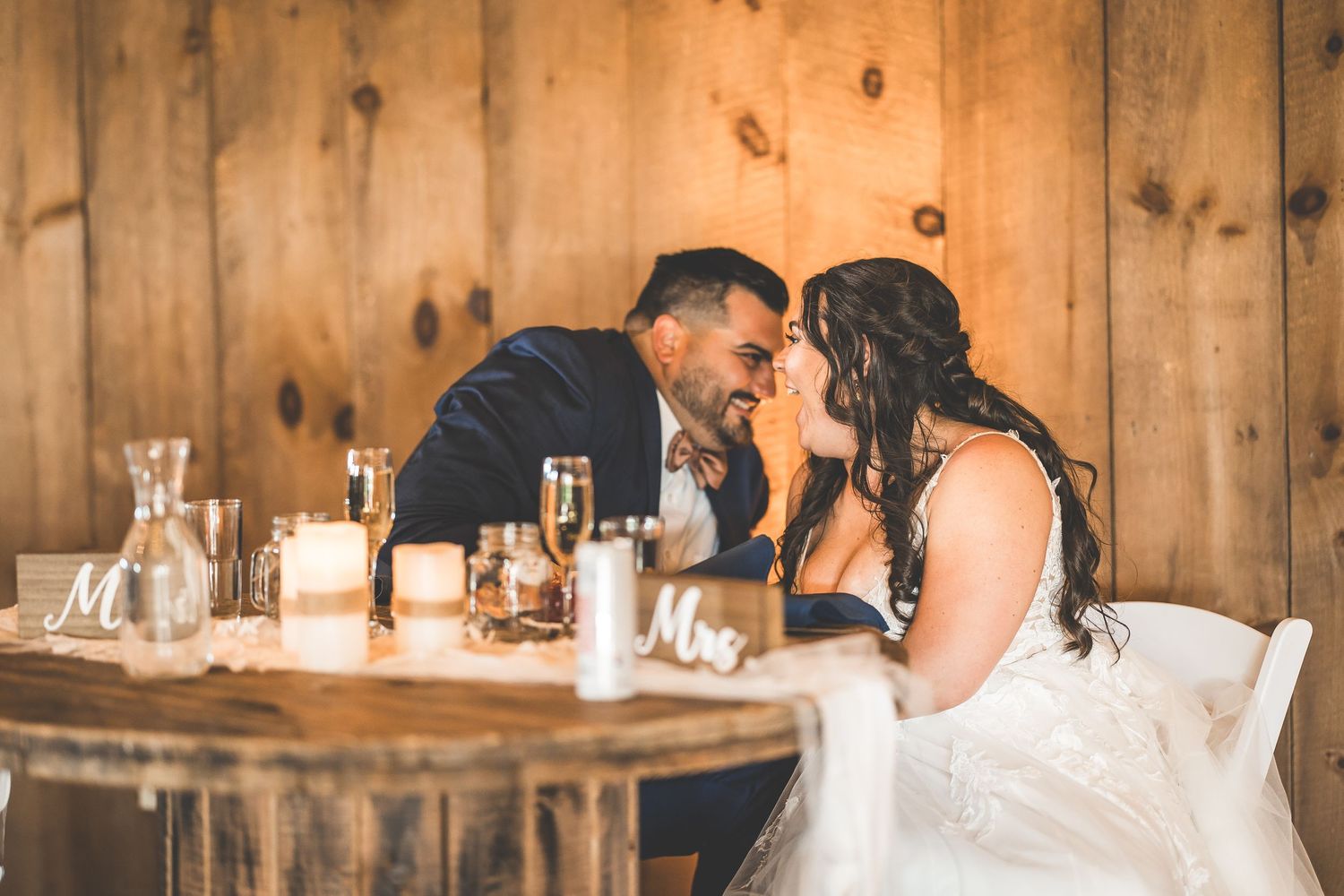 Intimate wedding reception moments in a charming barn venue with wooden walls.