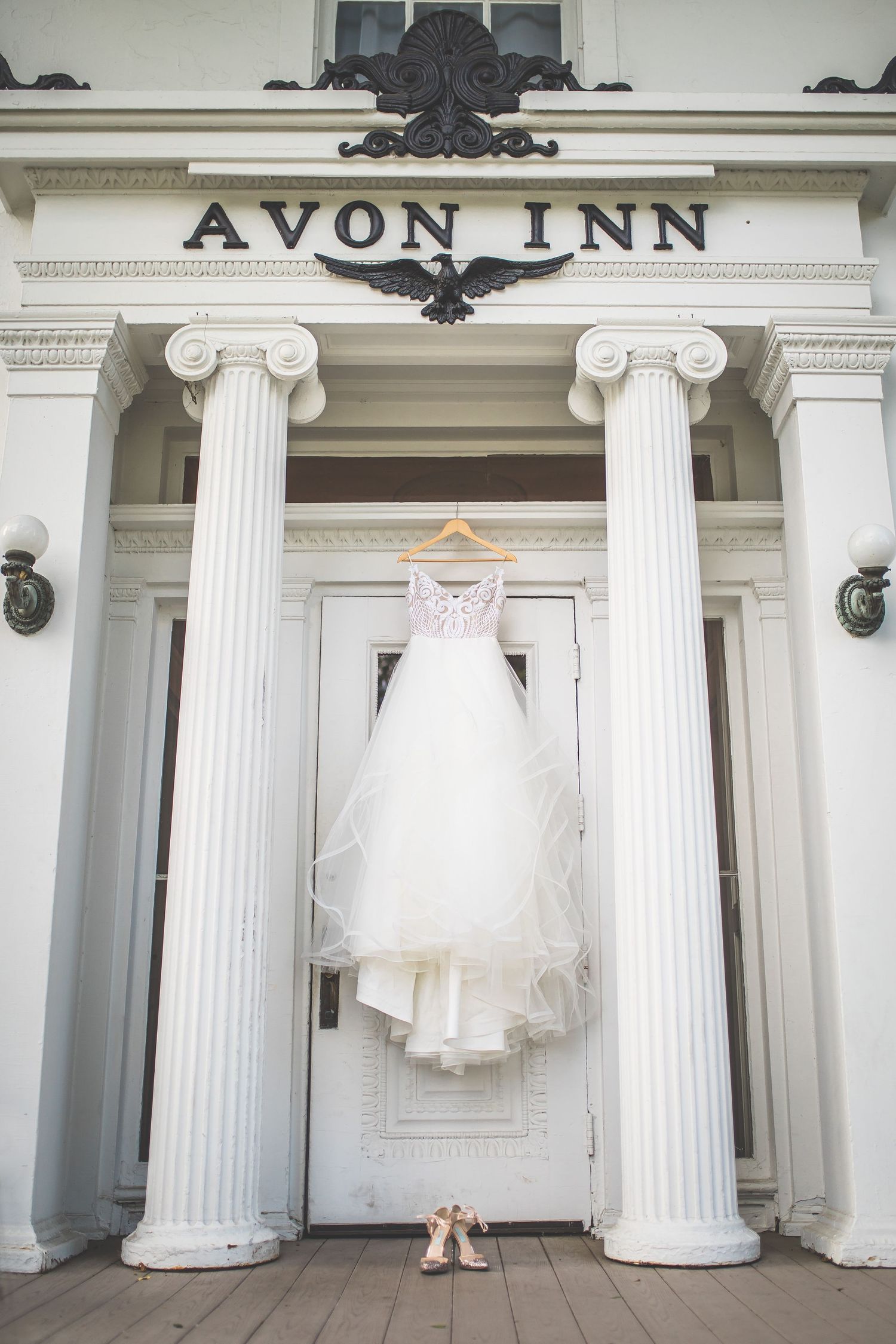 White wedding dress hanging outside the Avon Inn's classical columned entrance.