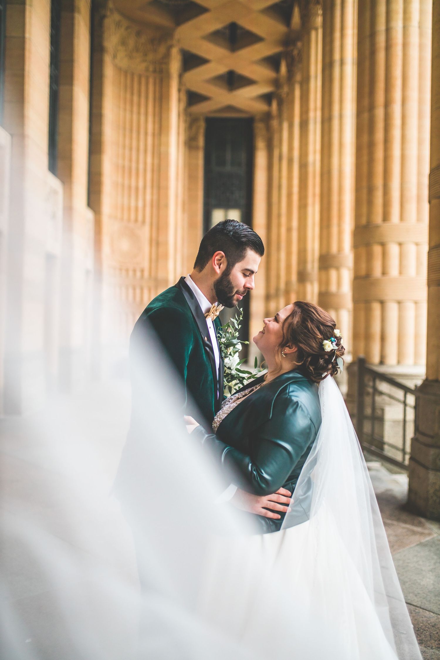 Romantic wedding portraits captured through columns with soft dreamy lighting.