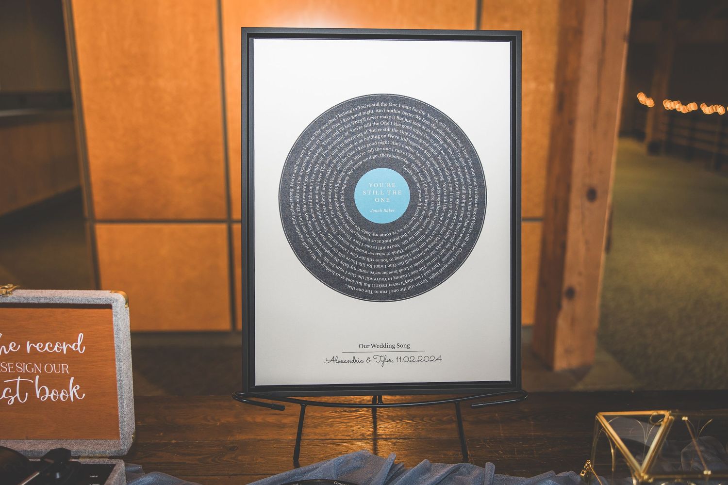 Framed minimalist vinyl record artwork print with blue center circle displayed on wooden surface.