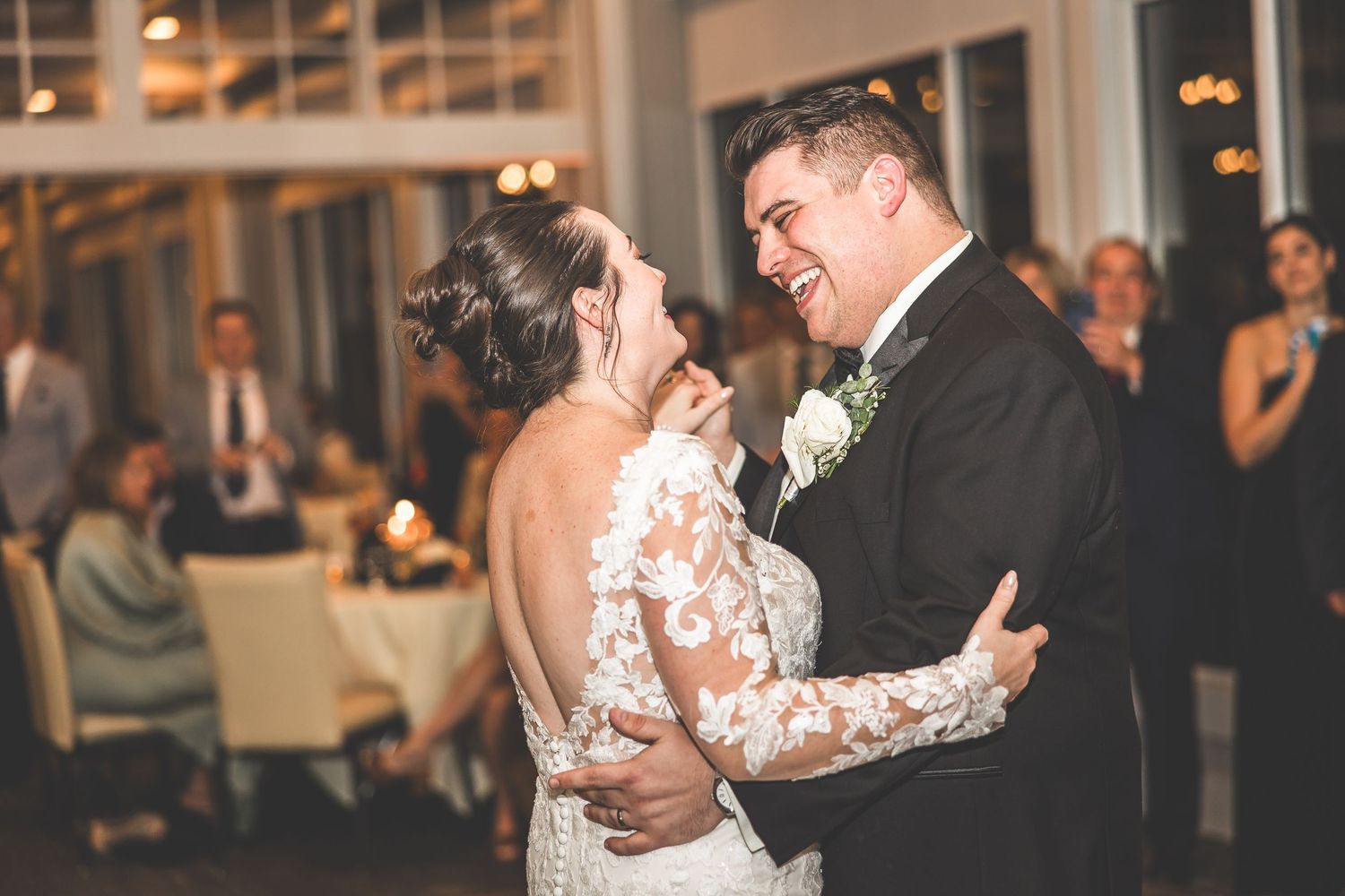 Couple shares their first dance in an elegantly lit reception hall.