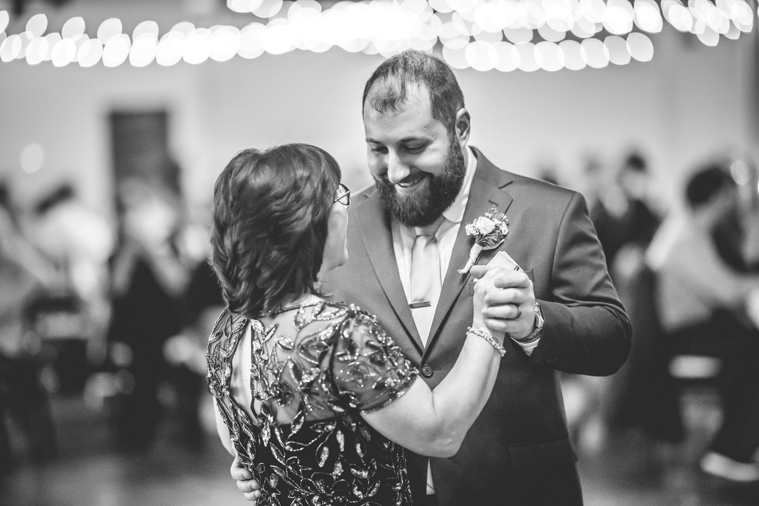 Black and white photo of couples dancing at an elegant wedding reception.
