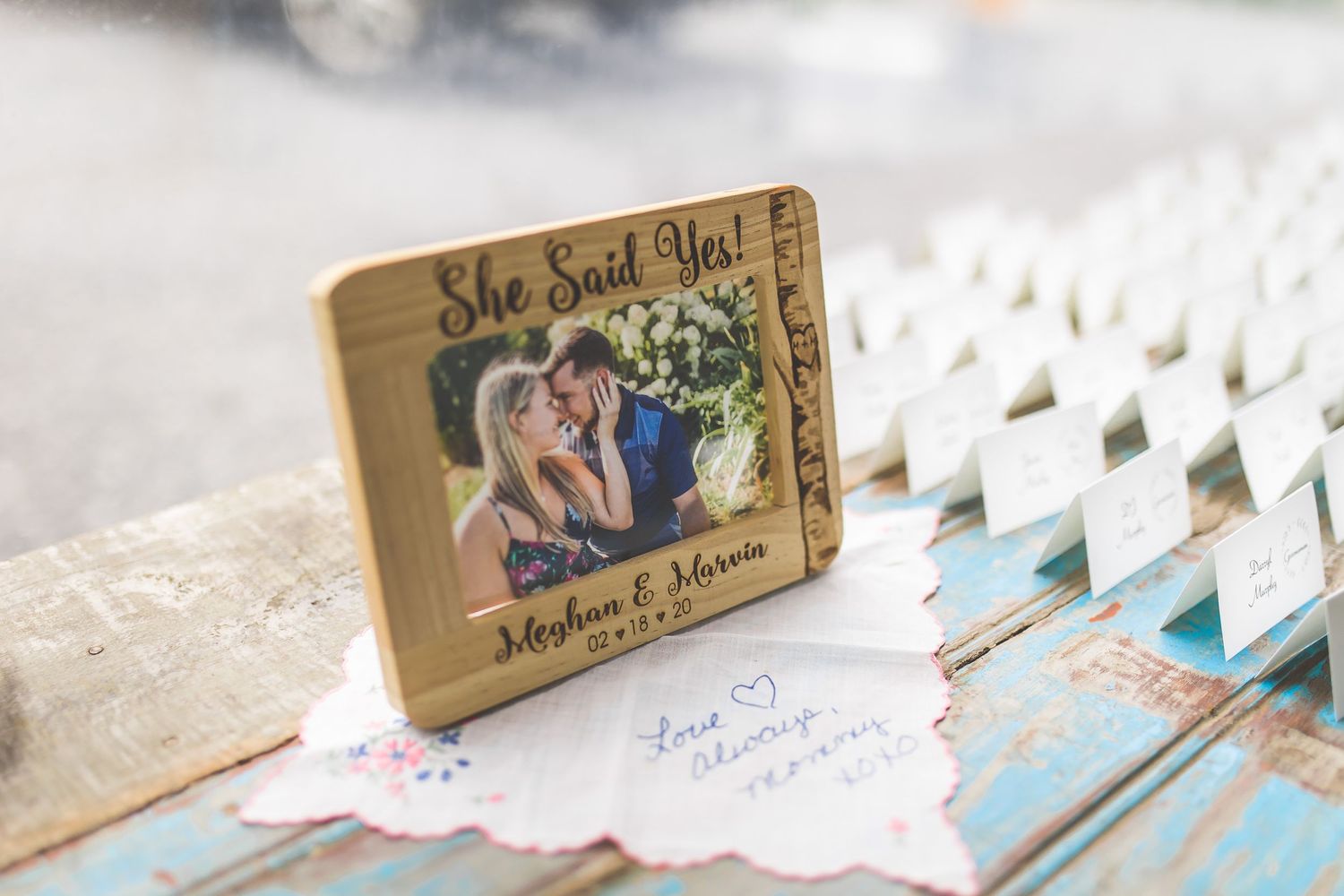 Wedding place cards and table settings arranged with rustic wooden decor elements.