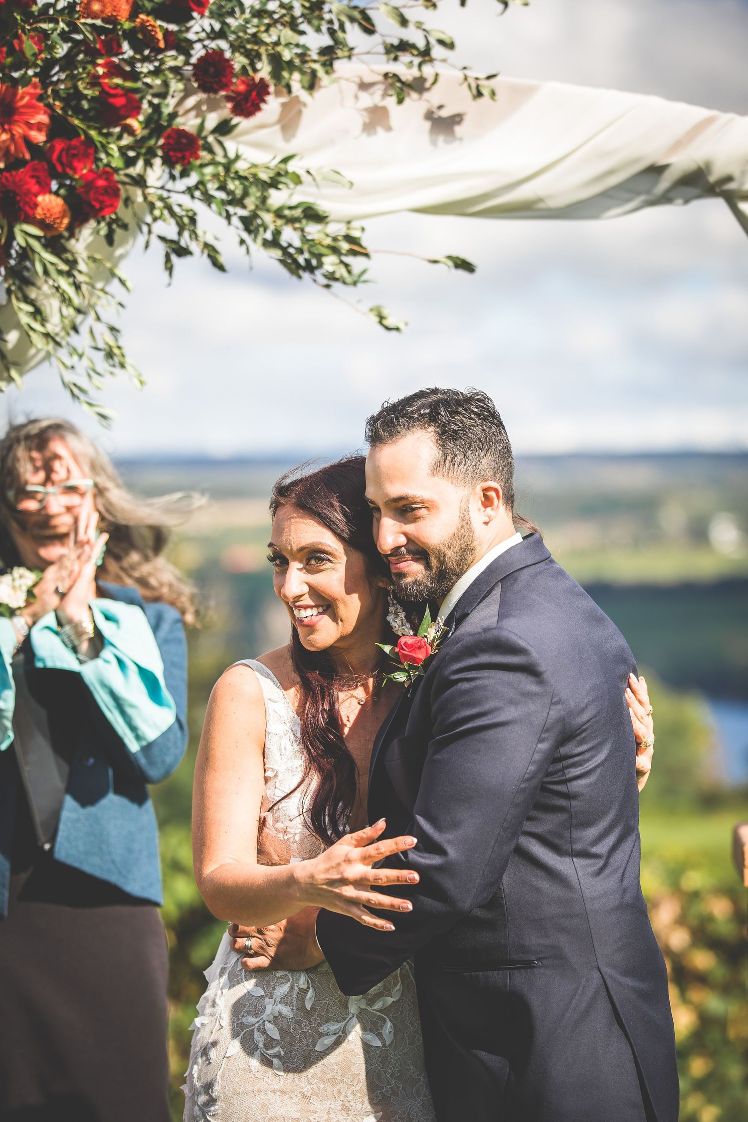 Joyful reactions during outdoor wedding ceremony with scenic backdrop.