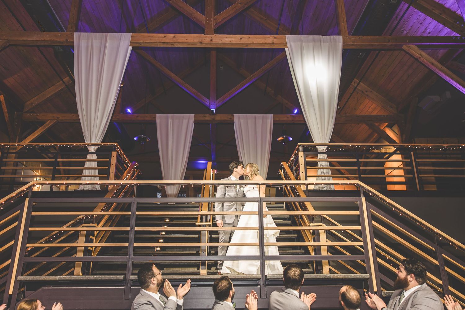 Elevated view of wedding venue with purple lighting and white fabric draping.