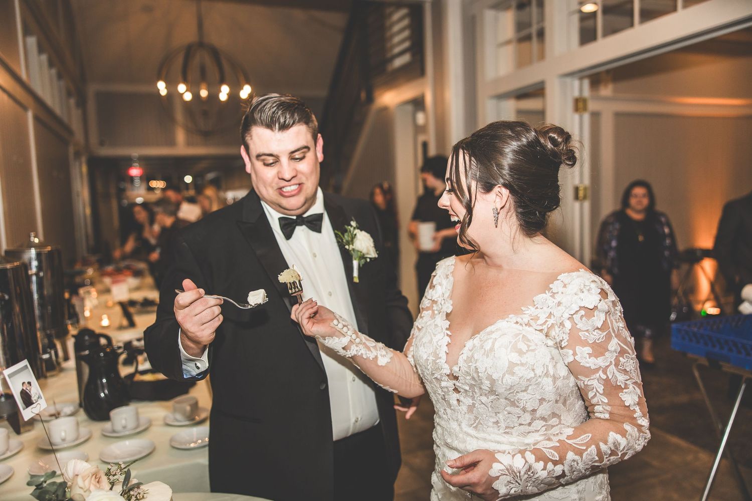 Couple shares a sweet moment while cutting their wedding cake at the reception.