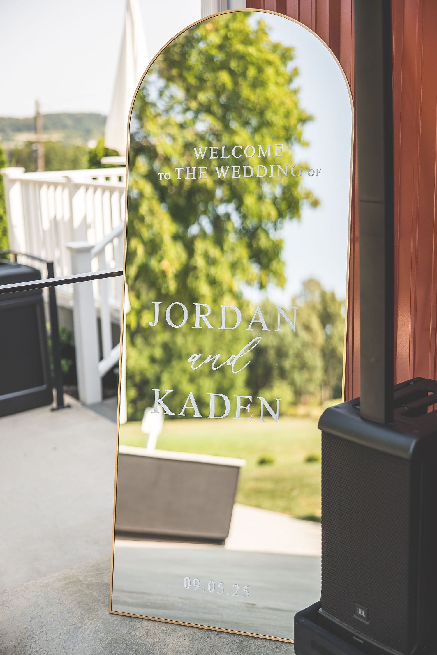 Modern wedding welcome sign displayed in an elegant gold-framed mirror.