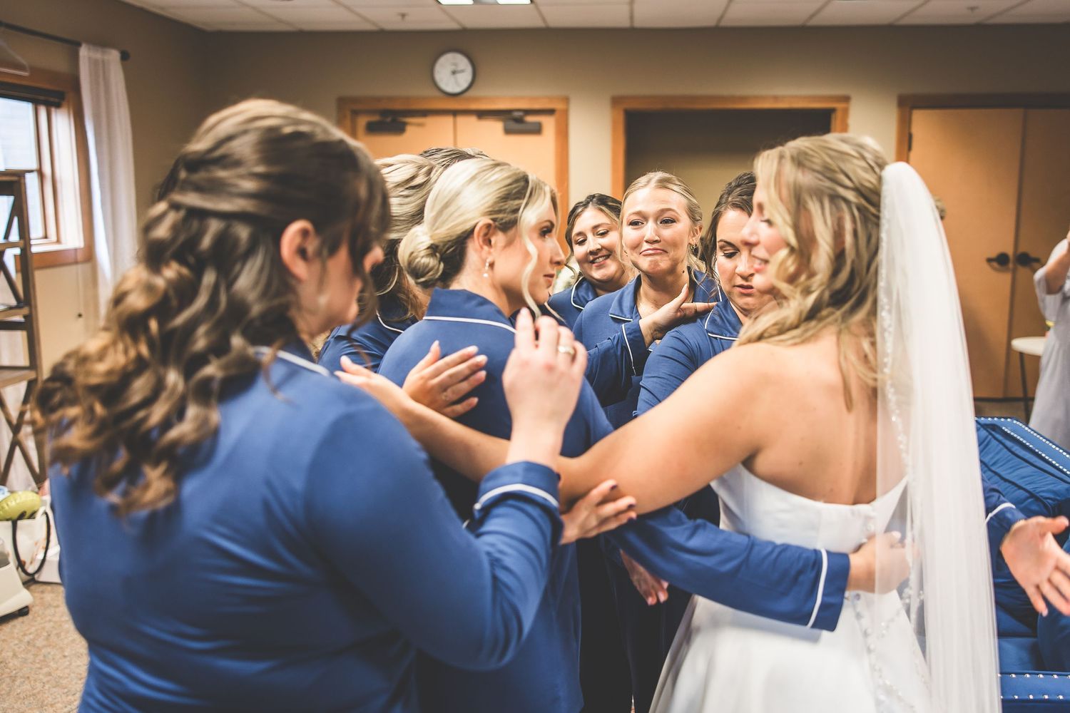Wedding party members in navy blue share an emotional reveal moment.