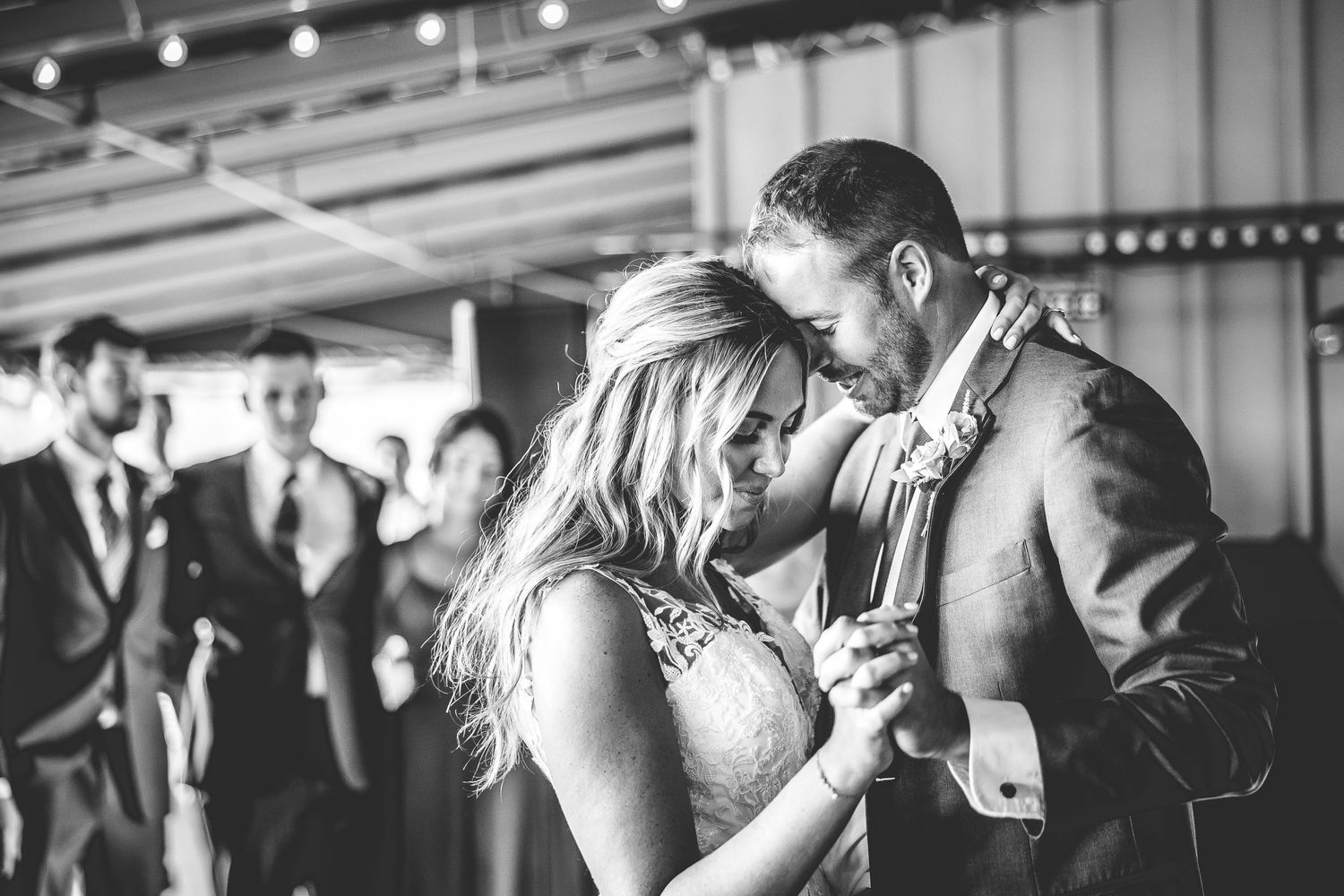 A romantic black and white photo of a couple dancing at their wedding reception.