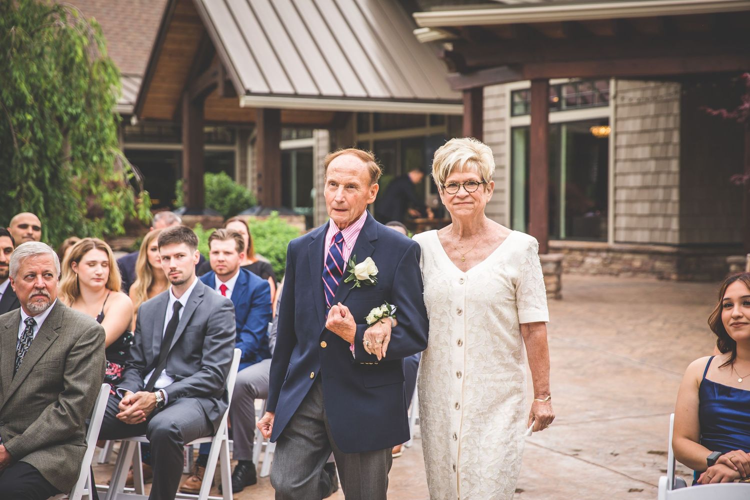 Guests and wedding party celebrate outside brick and stone wedding venue.