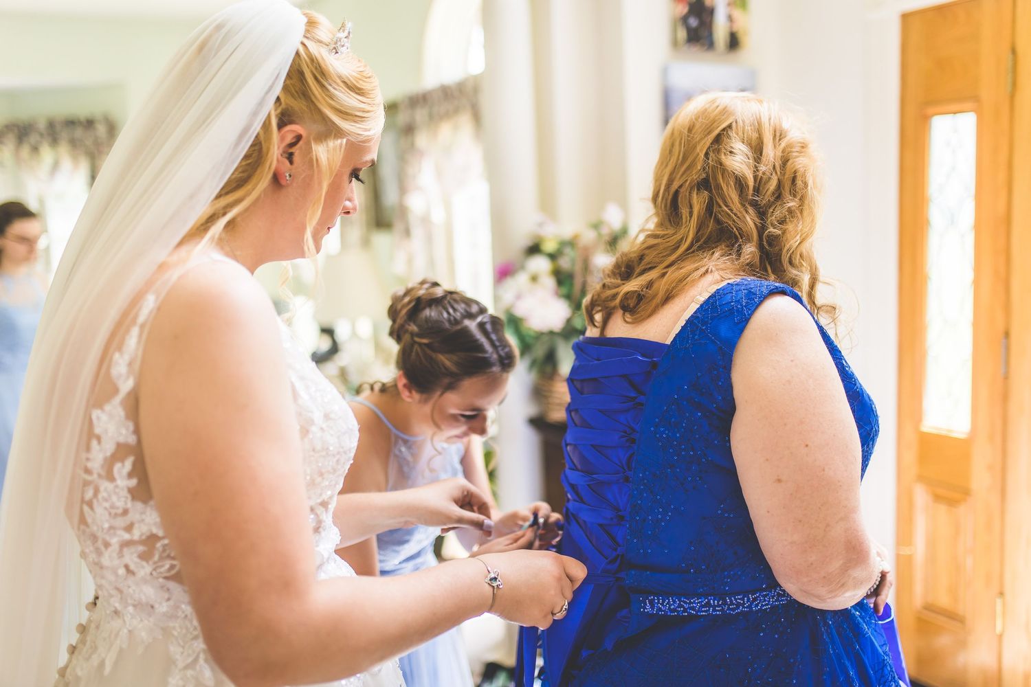 Wedding party members in royal blue dresses prepare for the ceremony.