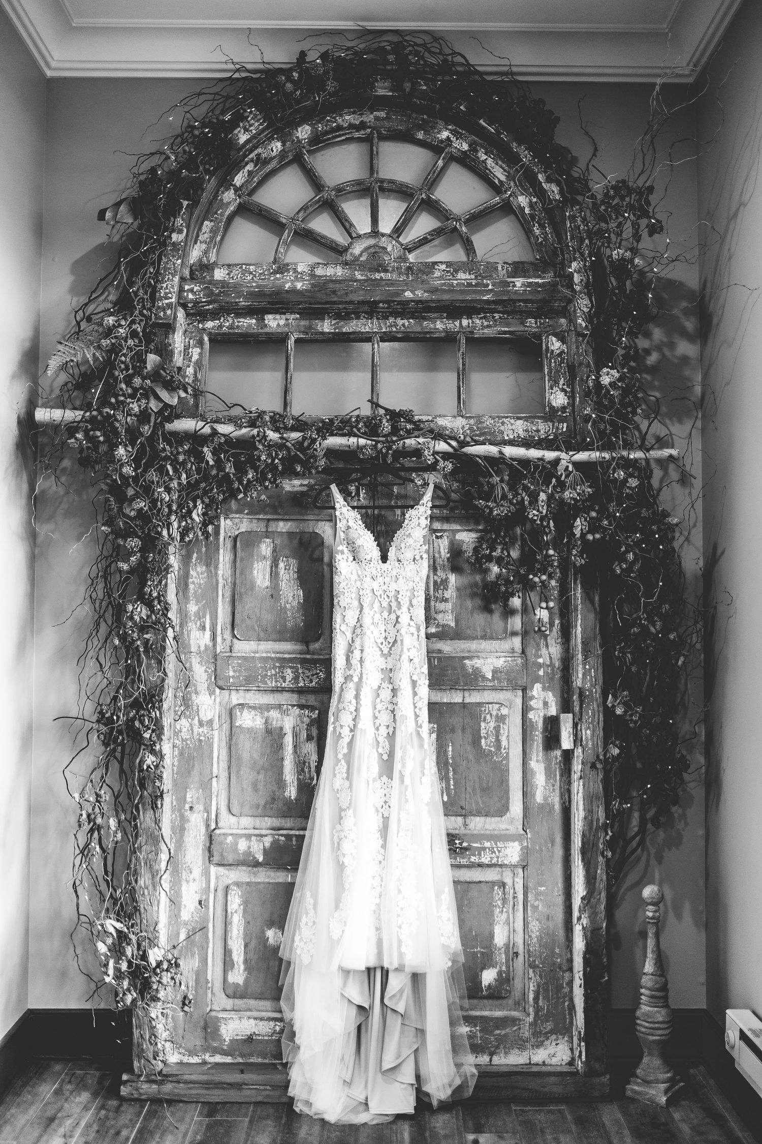 Wedding dresses displayed against vintage mirrors and archways adorned with elegant greenery.