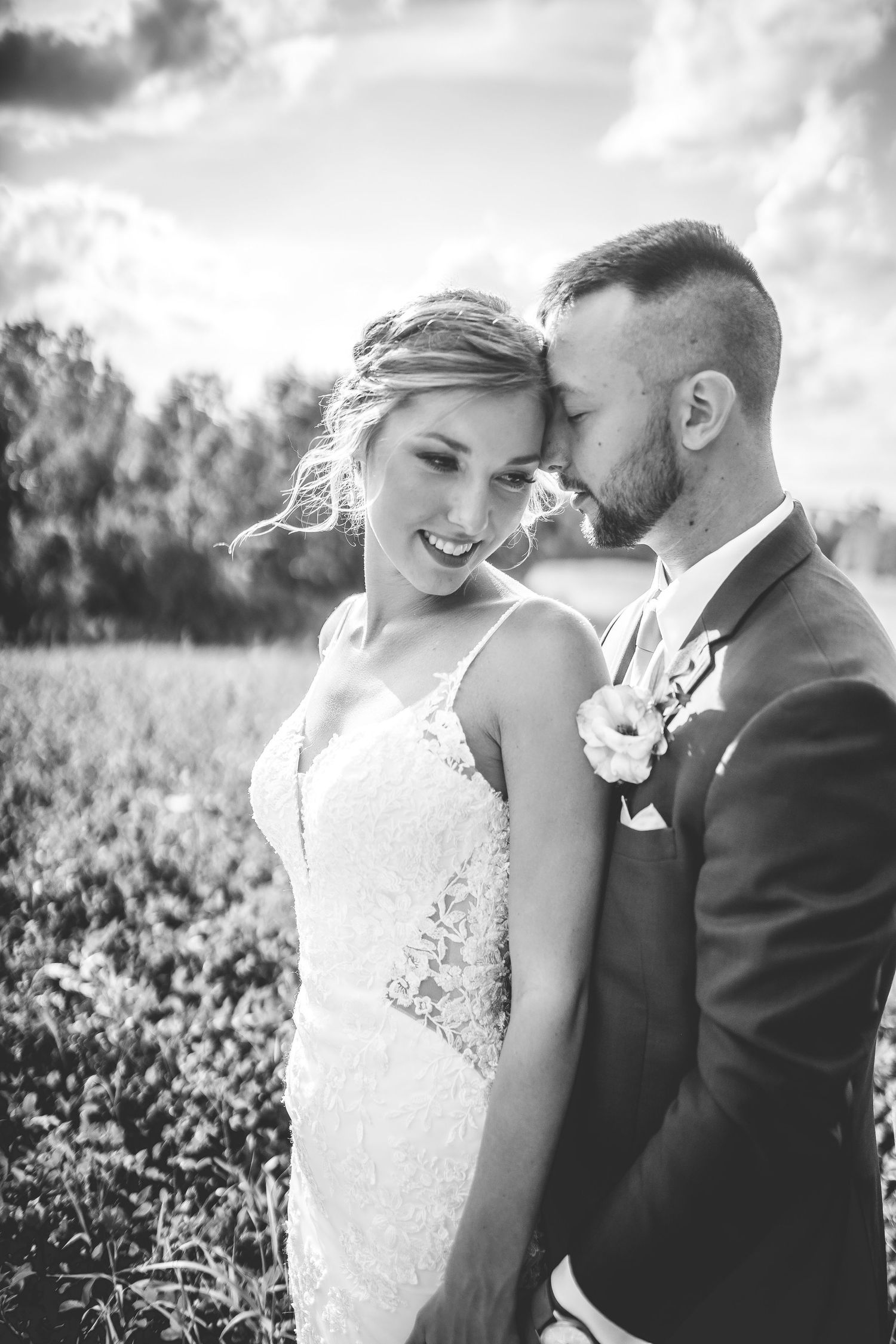 Black and white intimate wedding portraits captured in a natural outdoor setting.