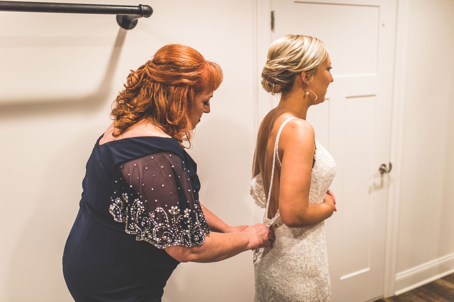 Wedding preparations in progress with formal attire being adjusted.