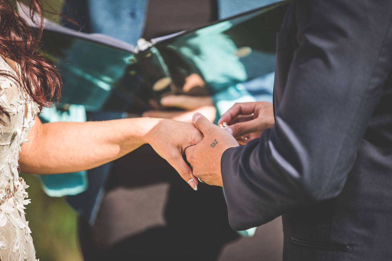 Detailed shots of ring exchange during wedding ceremony.