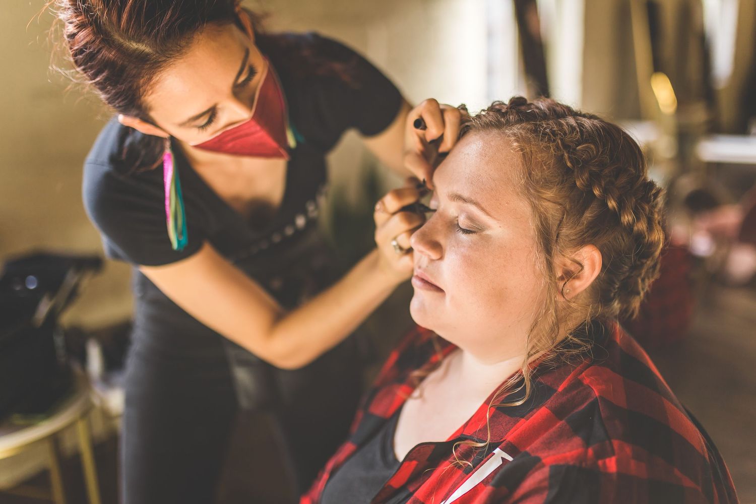 Wedding preparation scene showing final touches being made in warm indoor lighting.