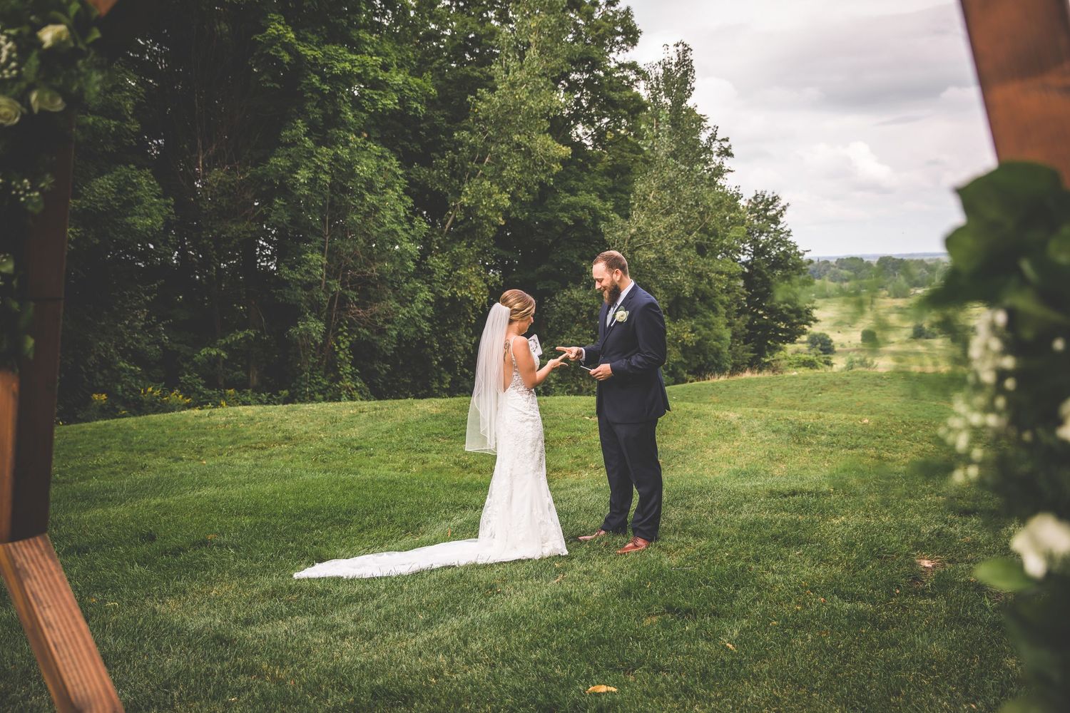 Wedding couple's first look photographed in scenic outdoor location with green landscape.