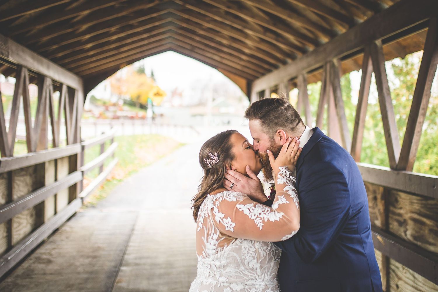 Romantic wedding moments captured inside a rustic wooden covered bridge.