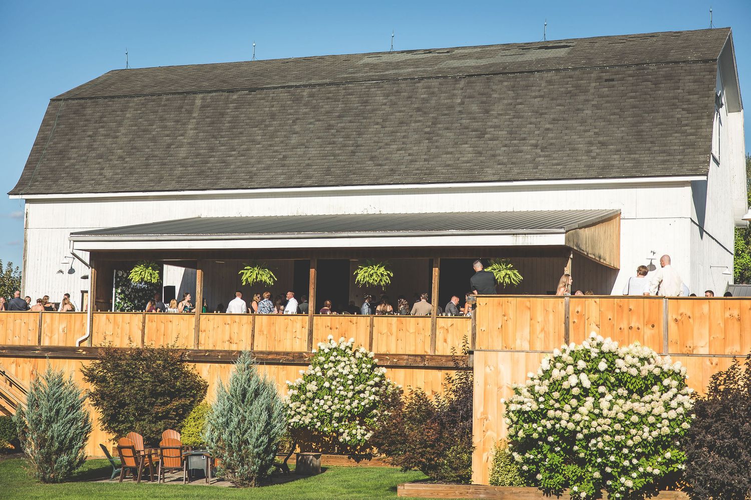 Exterior view of a residential house with wooden fence and landscaping in the backyard.