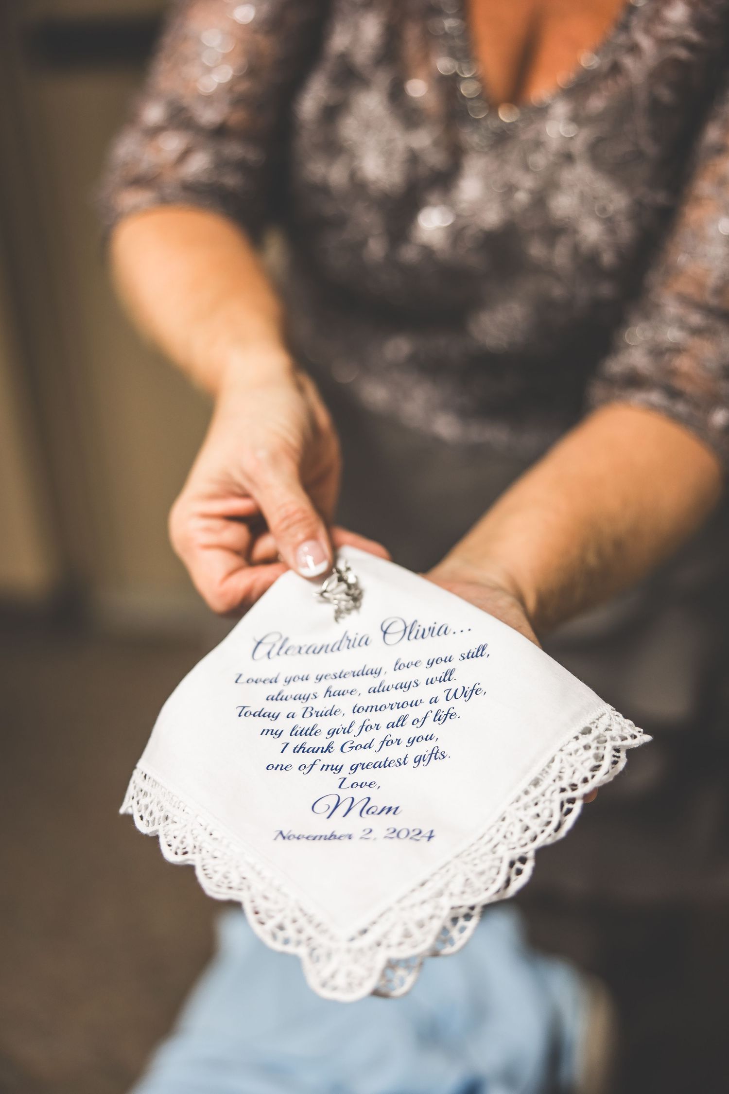 A delicate lace handkerchief with elegant script writing displayed against a soft background.