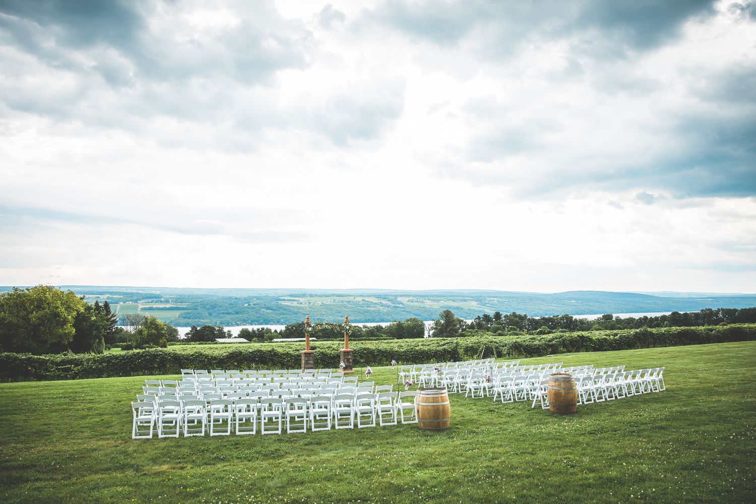 White chairs set up for an outdoor wedding ceremony with scenic mountain views.
