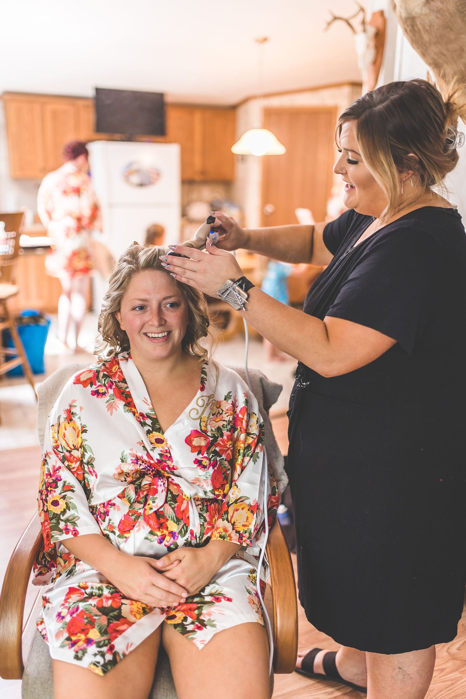 Getting ready scene with hairstyling in progress, wearing floral robe.