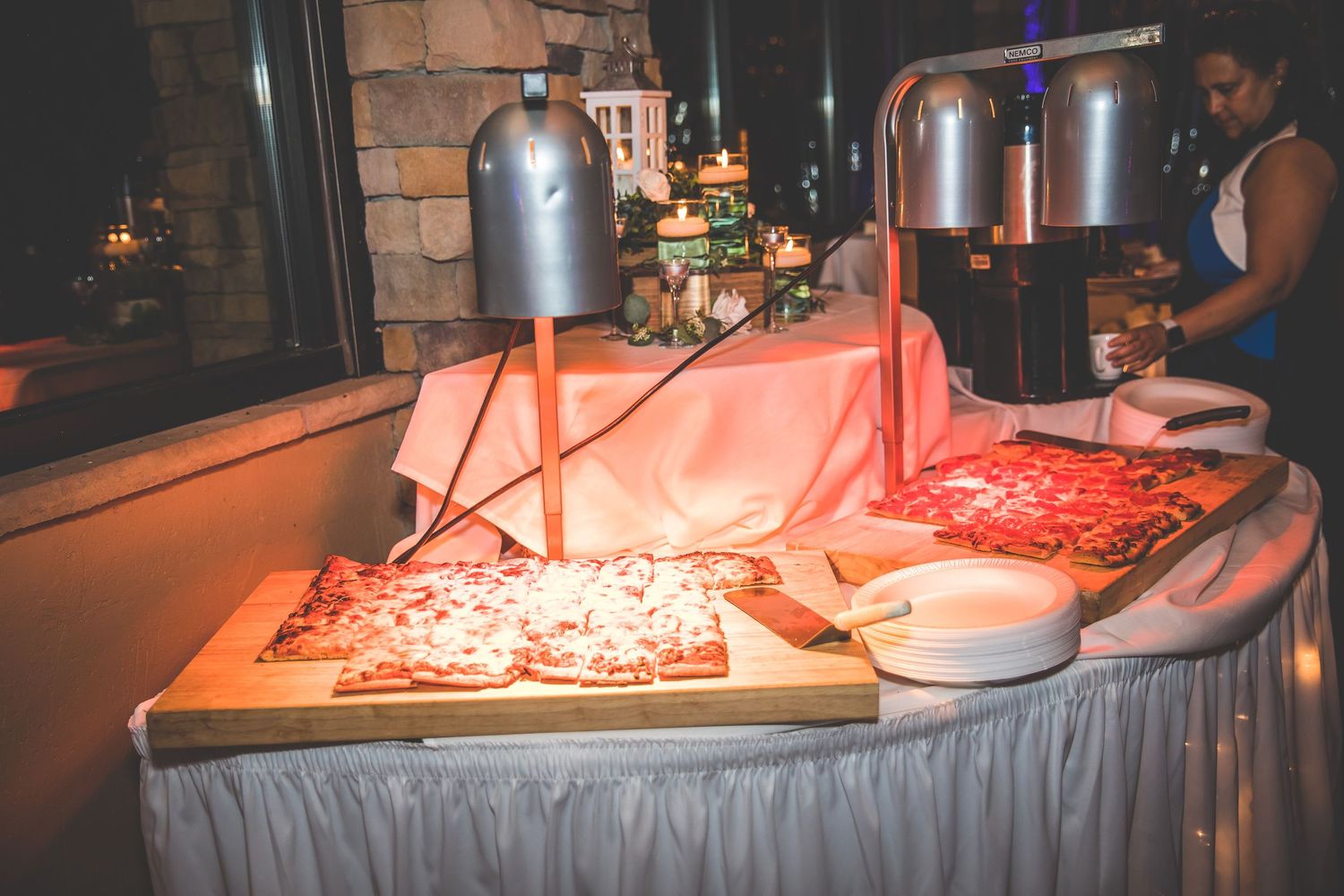 Elegant wedding reception setup with glowing red lighting and silver metallic decor.