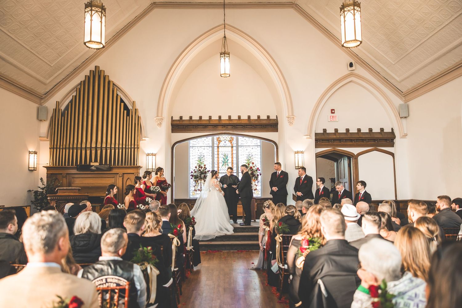 Church interior with vaulted ceilings, hanging lanterns and wooden architectural details.