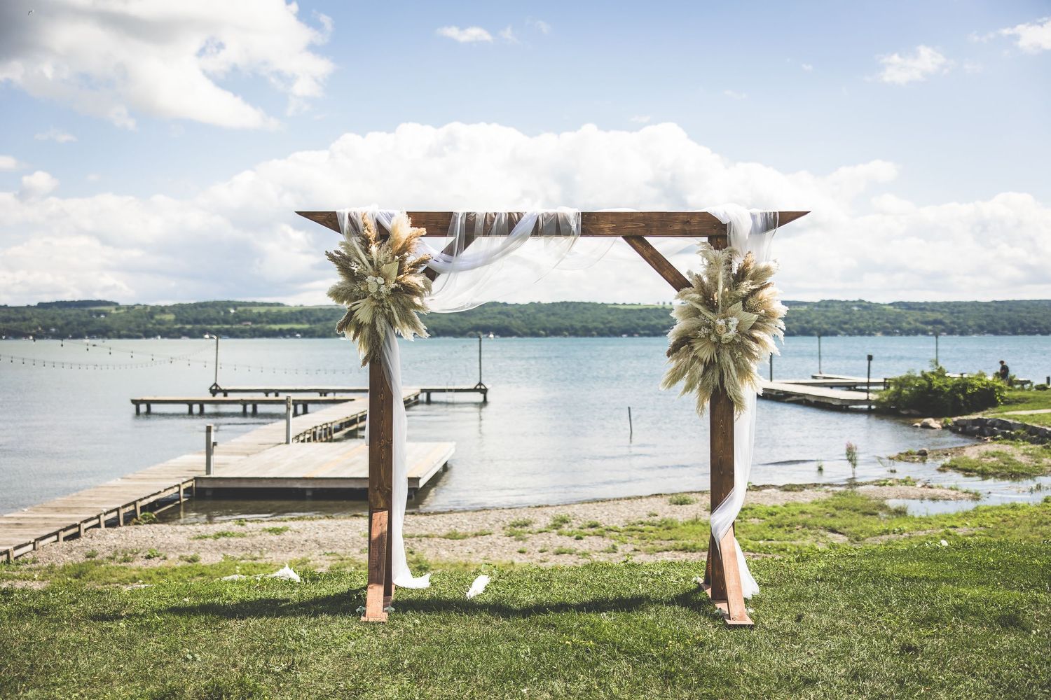Scenic waterfront view with palm trees, dock, and lake stretching to the horizon.