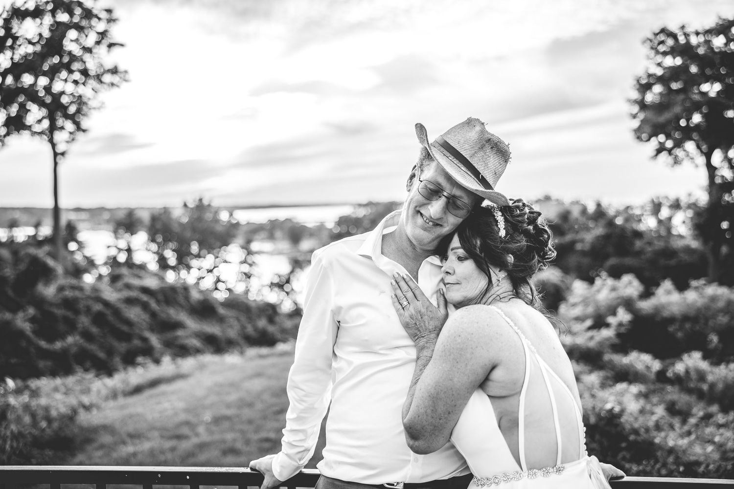 A couple shares a tender moment against a scenic landscape backdrop.